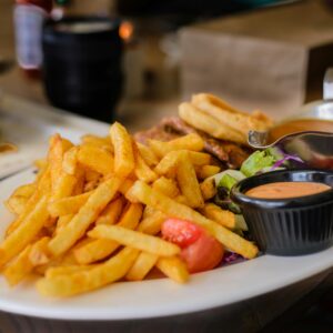 Delicious plate of golden french fries with dipping sauces, perfect for a satisfying meal.